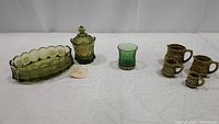 Two green Fostoria Coin Glass pieces, US Glass Co. green toothpick holder, vintage Japanese measuring cups.