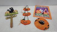 Photo showing the entire set of Halloween decorations including the wooden sign, hanging pumpkins, lantern, and wall hanging.