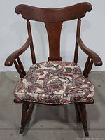Front view of solid wood Haverty's rocking chair showing curved backrest and paisley patterned cushion on seat.