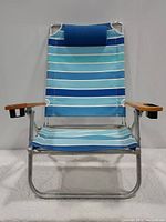 Front view of patio chair showing blue striped fabric, tubular metal frame, and wooden armrests with cup holders