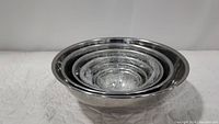 Set of seven stainless steel mixing bowls nested inside each other.