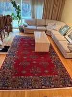 Overall view in living room showing full rug, adjacent furniture and scale