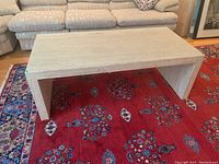 Full view of table top and one leg against sofa backdrop