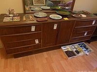 Front view of wood dresser with decorative items on top