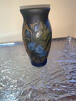 Side view showing blue and green floral pattern on a beige background with dark upper and lower edges.