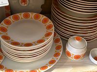 Stacks of plates and sugar bowl shown on shelf
