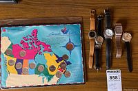 Full lot overview showing coin set on left and five wristwatches on right