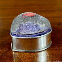 Heart-shaped sterling silver trinket box with a worn purple velvet stick pin lid, showing the shape and fabric wear