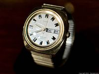 Front view of 1973 Timex men's watch showing silver dial, blue-inlayed black hour markers, day-date display indicating 'THU 14'.