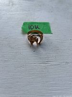 Front view of the 10K gold ring showing the horse head design on a white wooden surface with 10K label.