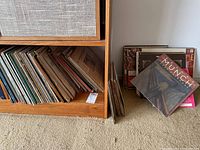 Shelf edge with mixed LP spines and loose stack on floor