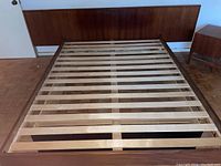 View of mid-century modern wooden platform bed frame with largest headboard and wood slat support base
