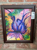 Frontal image of the framed acrylic painting showing the floral artwork and its colors against a brick background.