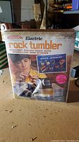 Front view of the vintage Saltcraft Electric Rock Tumbler kit box showing artwork, branding, and product details