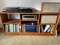 Full front view of the wooden shelf unit with multiple compartments. Various books and audio equipment placed on and inside the shelving for scale but not included in sale.