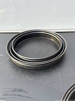 Three round metal cake pans stacked in descending size order, showing nesting capability.