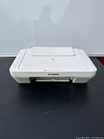 Front view of the Canon printer including the front paper output slot and top scanner lid.