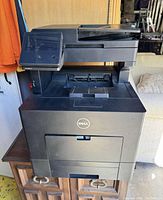 Front view of Dell Color Smart Multifunction Printer showing display screen, control panel, output trays and Dell logo on front.