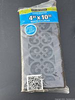 Floor register in original packaging showing 4x10 inch size and decorative design.