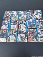 Photo showing 15 football trading cards laid out in a grid, each card featuring a football player in different team uniforms and poses.