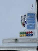 Magnetic dry erase board with markers, erasers, mounting hardware, and instruction sheet arranged on white background.