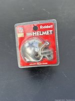 Front view of Riddell Pocket Chrome helmet featuring the Dallas Cowboys star logo in original packaging.