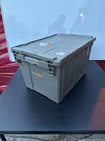 Full view of gray plastic storage container with lid, showing condition and structure.