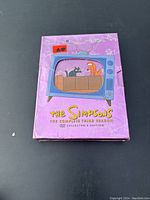 Front of DVD box set showing purple sleeve with TV illustration and Itchy & Scratchy characters, text in yellow.