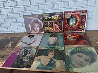 Photo of the 10 vinyl record album covers laid out on table, showing condition and artwork