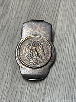Front view of the vintage sterling silver money clip showing Mexican coin embedded with eagle and snake design and inscription.