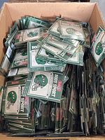 Top-down view of cardboard box filled with numerous sealed New York Jets temporary tattoo packages.