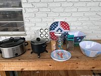 Overview of all kitchenware including Crockpot, pot, mixing bowls, muffin pan, patriotic baking pans, glass bottle, butter dish, and box grater.