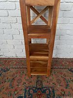Side view of the four-level hardwood shelf showing cross-bracing and wood grain