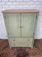 Front view of the Hart Furniture green cupboard with two doors and two drawers.