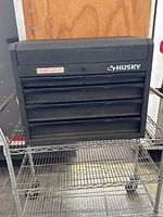 Exterior front view of black Husky toolbox with brand logo and model details visible