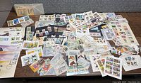 Top-down view of a large collection of animal stamps, First Day Issue covers, and loose stamps spread on a table, including various sizes and formats.