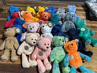 Full lot of 22 plush bears arranged in rows showing different colors and states each with a quarter mounted on the chest.