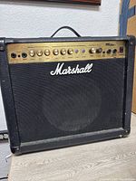 Front view of Marshall MG Series 30DFX amplifier showing black cabinet and gold control panel with Marshall logo and speaker grille.
