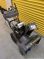 Front-side view showing chute, intake housing, auger and wheels