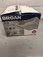 Closed retail box of Broan DX70L ventilation fan-light showing brand and model details.