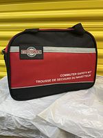 Full front view of MOTOMASTER branded red and black carrying case with zippered closure and handle, labeled 'Commuter Safety Kit'