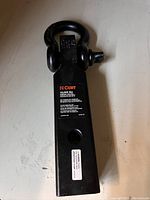 Photo showing the front view of the Curt D-Ring shackle mount with product label visible stating 13,000 lbs rating and Curt branding.