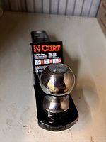 Front view of loaded ball mount with 2 inch ball and Curt label showing load capacities