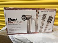 Sealed product box front displaying Shark FlexStyle branding, main unit and attachments illustration
