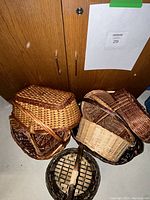 Woven baskets grouped together on floor showing diverse sizes and handles