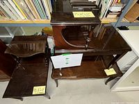 Three vintage wooden tables seen together: two end tables and one coffee table with dark polished wood finish, varying shapes and lower shelves.