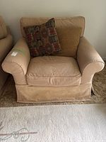 Front view of beige Restoration Hardware slipcover armchair with two cushions, showing rolled arms and skirted base. Some visible wear and stains on slipcover.