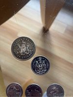 1971 Canadian Dollar coin featuring British Columbia provincial crest and 1978 Canadian 50 cent coin with provincial insignia, additional coins below partially visible