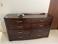 Full view of the long wooden dresser showing eight drawers and dark brown finish.