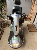 Front view of silver Invacare Pegasus scooter with black vinyl seat and illuminated headlight